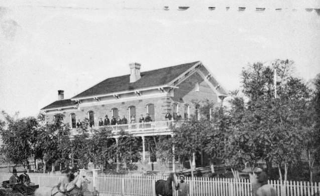 #175 Home of W. H. Williams with a group of people posing outside on the balcony.W. H. Williams Home 1887.