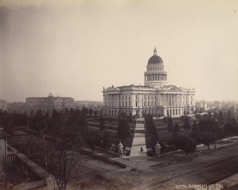 #39 Angle view of the capitol building in sacramento, railroad tracks are seen in the foreground, and the rest of the city is seen spread out beyond, 1880