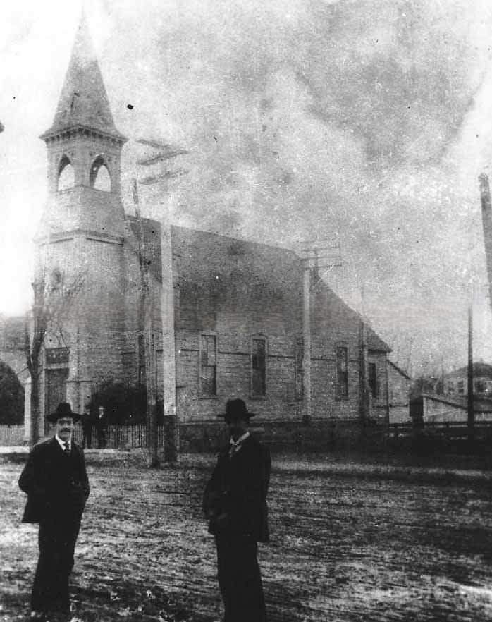 #84 An unidentified church and two men standing in the street in front of the church, 1880