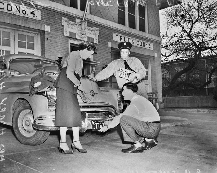 #45 Frank Monaco watching as license plates are removed from car, 1953