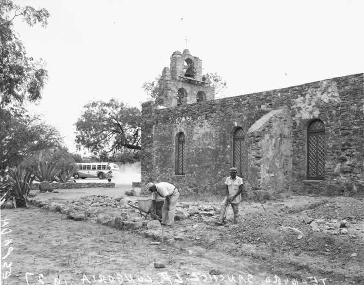 #17 Teodoro Sanchez and L.P. Longoria working outside the church at Mission Espada, 1956
