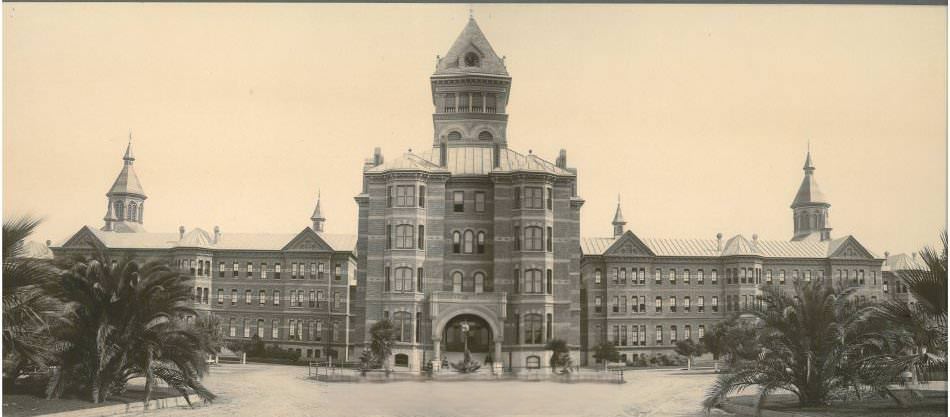 #30 Front of Agnews State Hospital pre-1906 earthquake, showing full extent of building. Palm trees flank the left and right side of the driveway.