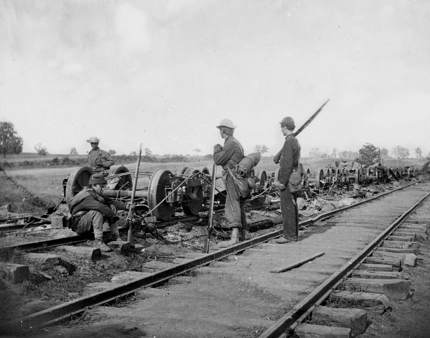 #81 Soldiers stand beside damaged rolling stock of the Orange & Alexandria Railroad, 1862