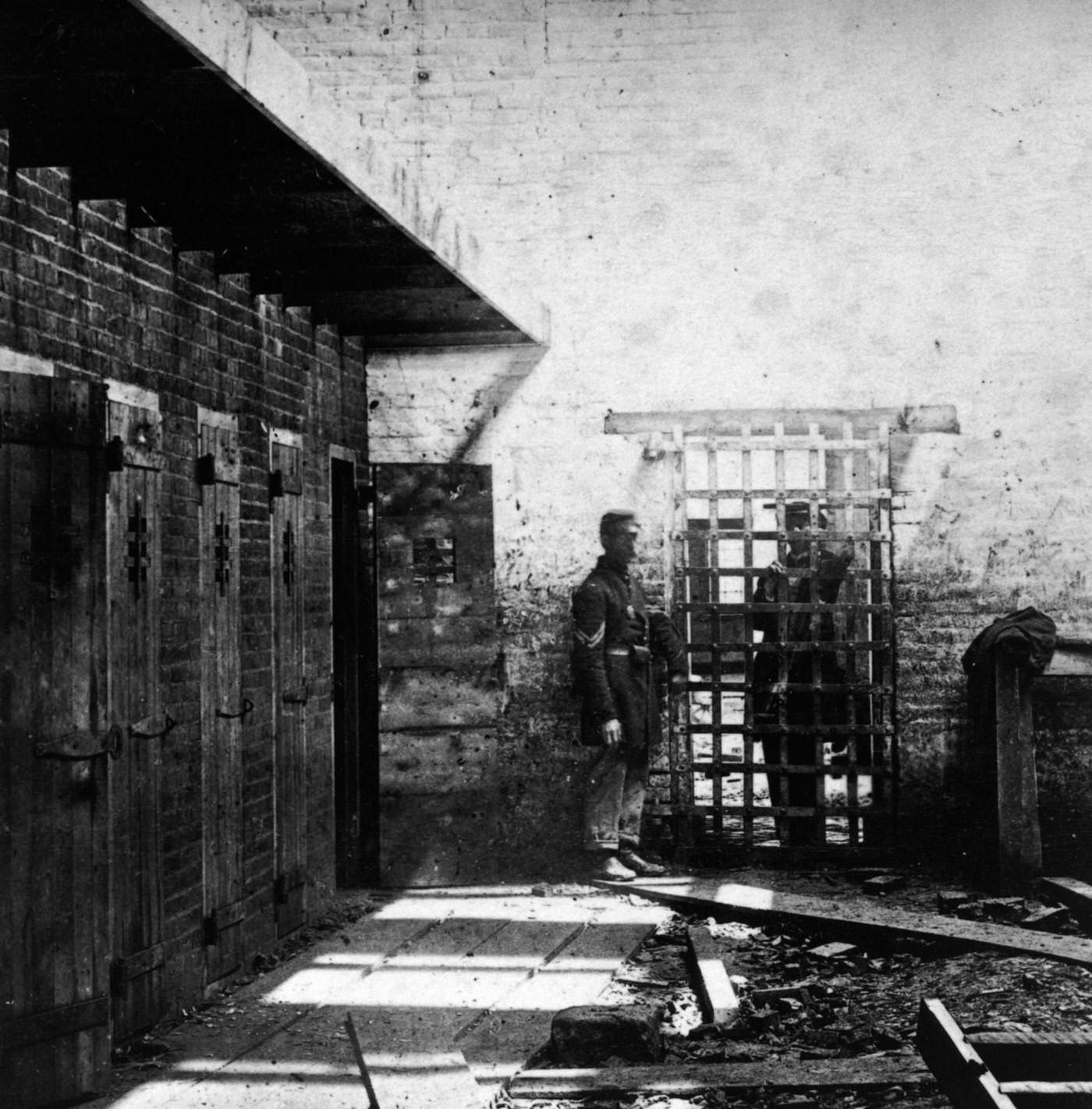 #158 Two soldiers stand beside slave pen cells in Alexandria, Virginia, 1861.