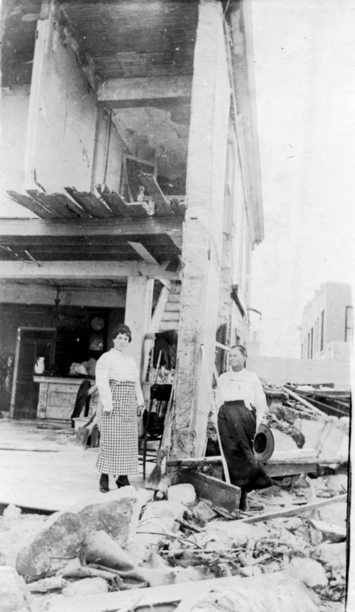 #56 Two women standing beside the damaged building at the Seaside Hotel after the 1919 hurricane in Corpus Christi.