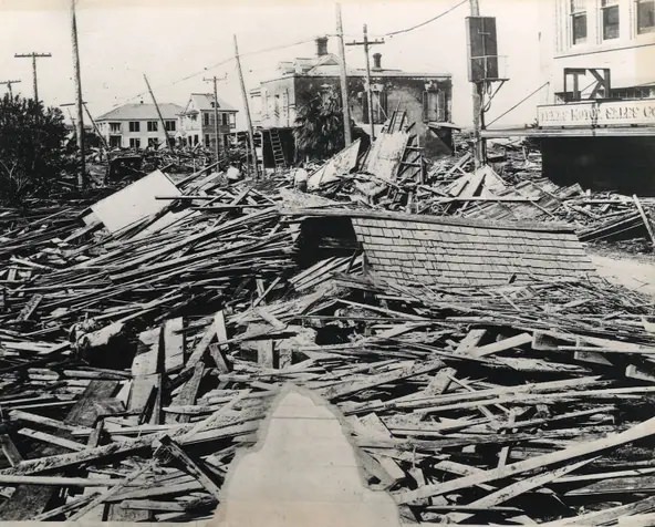 #82 Lumber and other debris buries the 700 block of Mesquite Street in downtown Corpus Christi after the 1919 hurricane. On the right is the Texas Motor Sales Co.