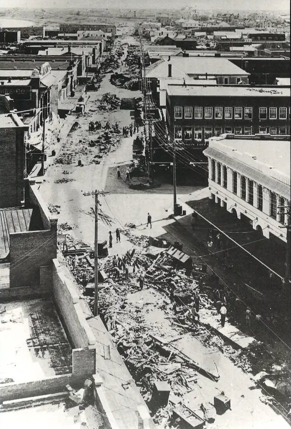 #80 This photo was taken from the top of the Nueces Hotel looking south down Chaparral Street as men cleared debris following the 1919 hurricane.