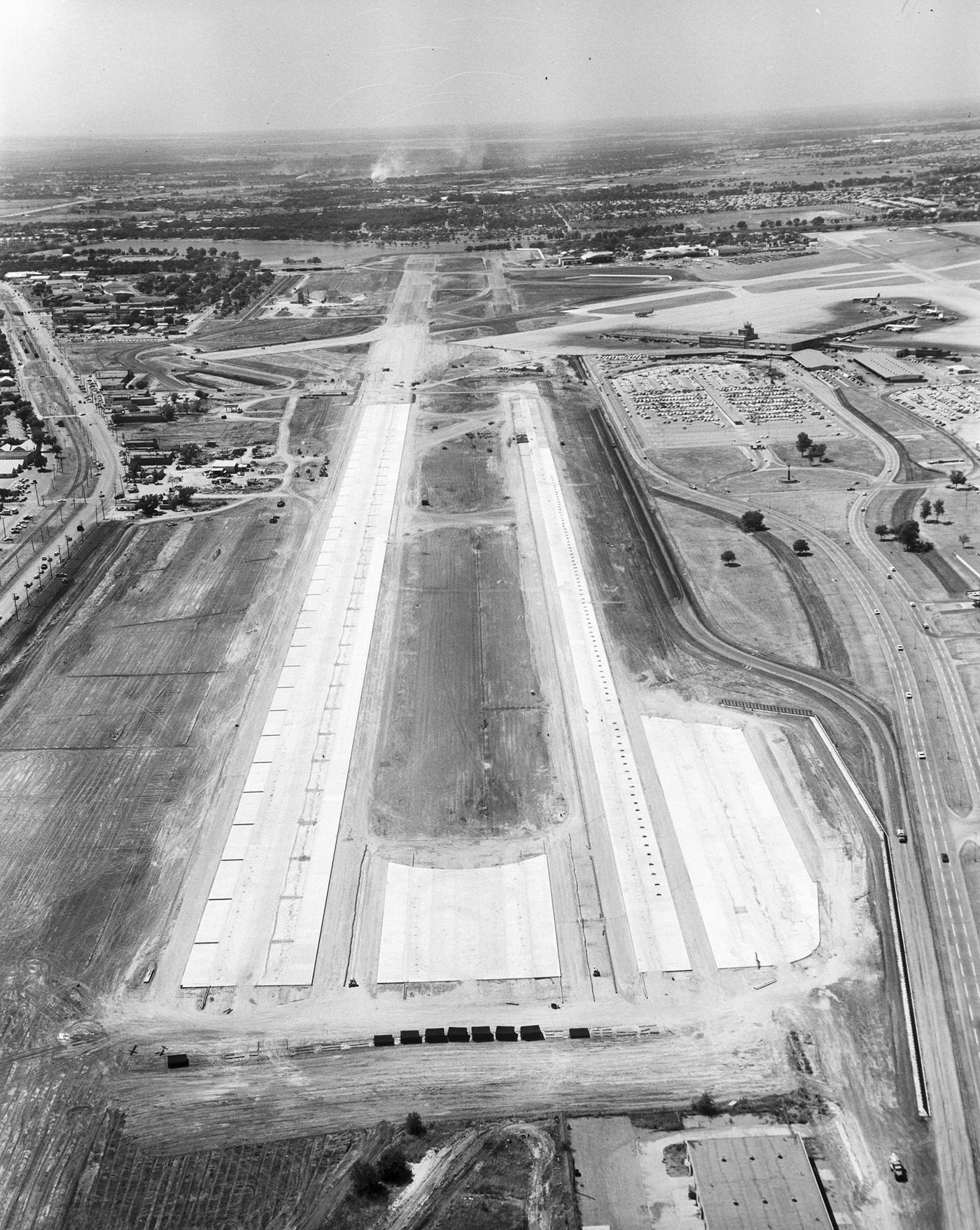 #51 Runway at Love Field, Dallas. There are airplanes parked, 1960
