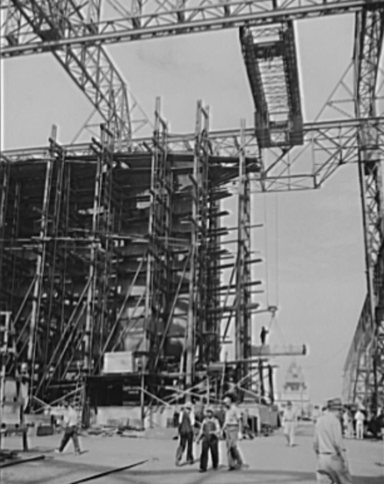 #14 Shipbuilding in Newport News. Through the scaffolding may be seen the prow of a battleship under construction, 1941