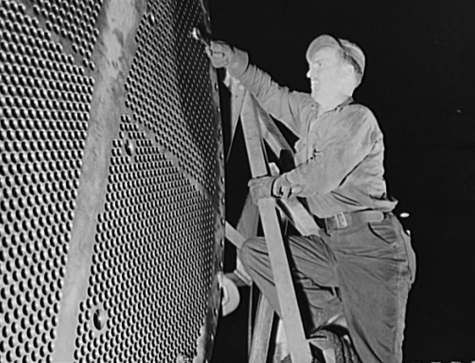 #26 This worker is touching up one of the huge condensers for a U.S. Navy destroyer under construction, 1941