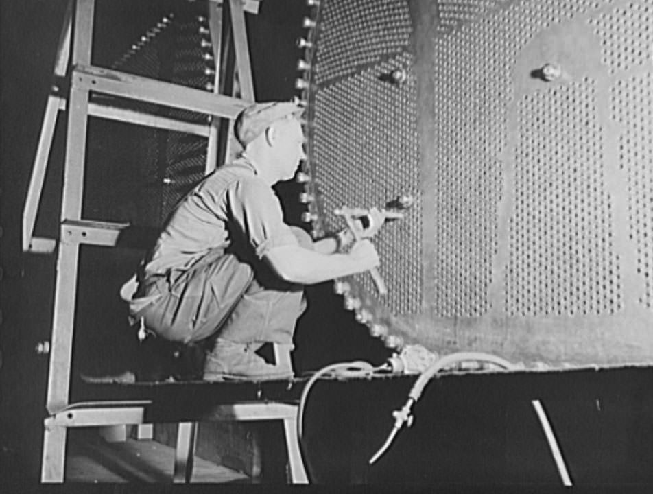 #28 This worker is touching up one of the huge condensers for a U.S. Navy destroyer under construction, 1941