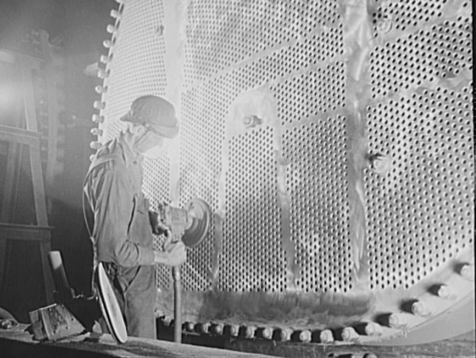 #29 A worker is touching up one of the huge condensers for a U.S. Navy destroyer under construction, 1941