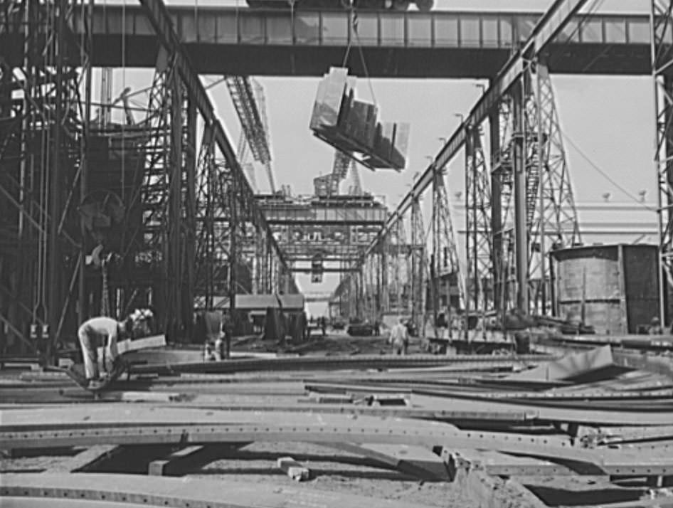 #35 A section for a new U.S. Navy cruiser is being delivered by overhead crane to the building ways, 1941