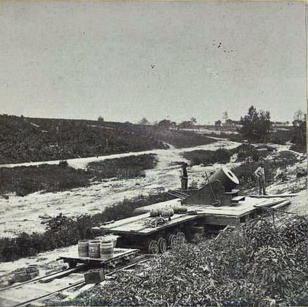 #60 Union soldier standing near a 13 inch mortar on a platform on a flatbed railroad car near Petersburg, Virginia, 1864