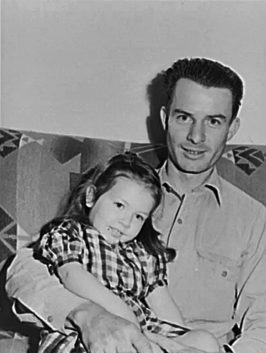 #82 A man and his daughter pose for pictures at Camelback Farms in February 1942.