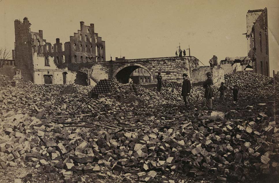 #145 Two soldiers, three boys and piles of cannonballs among ruins, 1865