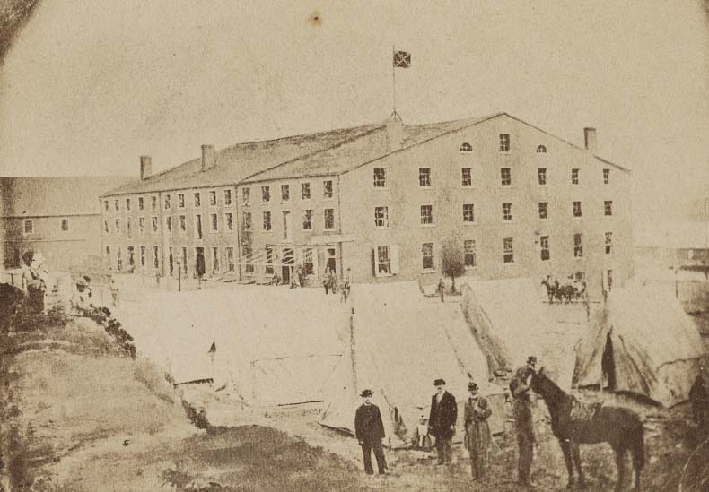 #46 Men and a horse next to tents in front of Libby Prison, Richmond, Virginia, 1863