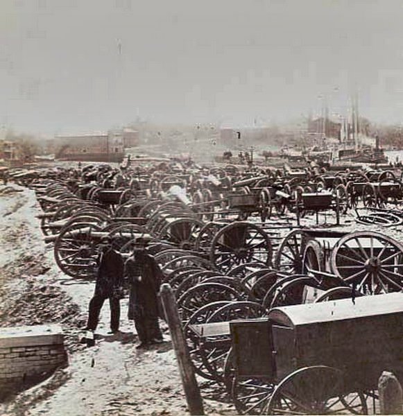 #105 Two Union soldiers standing amid the cannons and caissons captured by the Union near Rocketts in Richmond, Virginia, 1865