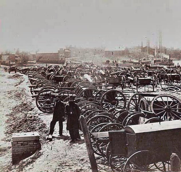 #106 Two soldiers standing amid the cannons and caissons captured by the Union near Rocketts in Richmond, Virginia, 1865