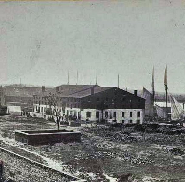 #120 Exterior view of the prison with people milling about in the prison yard, Richmond, 1865
