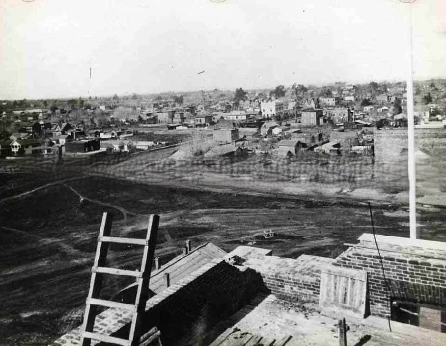 #80 Cityscape of Sacramento taken from the state capitol building under construction. Typed on the back of the image “Corner of 10th & N street in the year 1868.