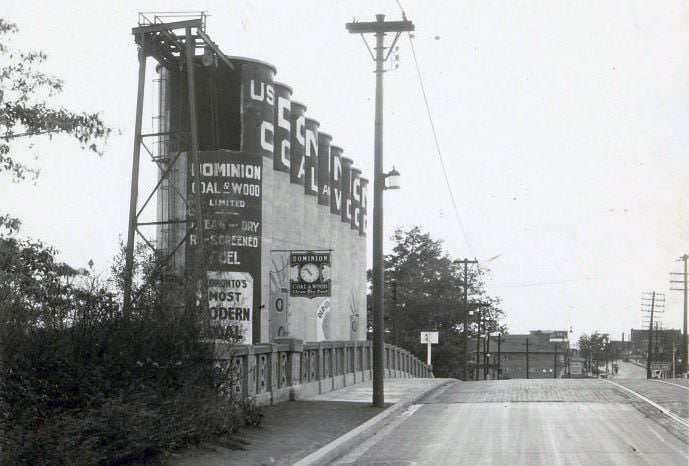 #104 Dominion Coal & Wood Limited – Item is a photograph of signage painted on a set of silos located on Mount Pleasant Road, at Merton Street, 1934