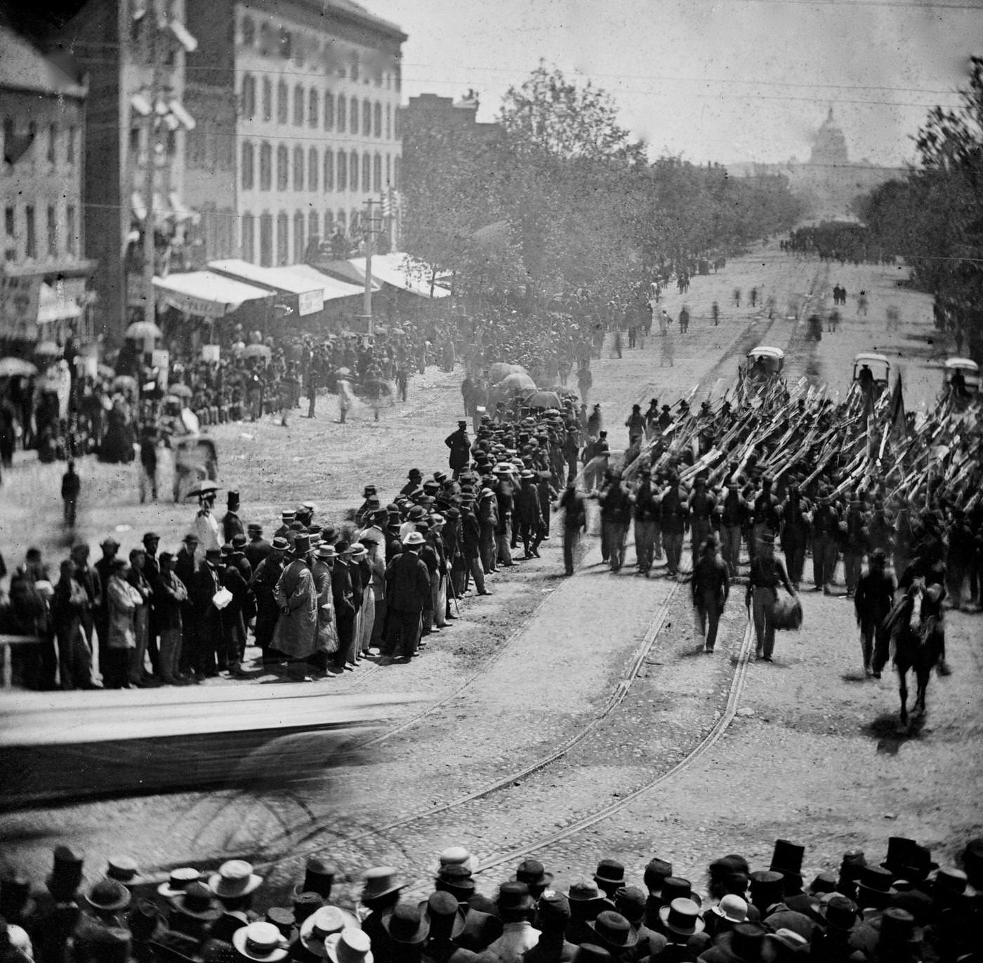 #168 Infantry unit with fixed bayonets followed by ambulances passing on Pennsylvania Avenue near the Treasury, during the “grand review” of the Union Army, Washington, D.C., 1865