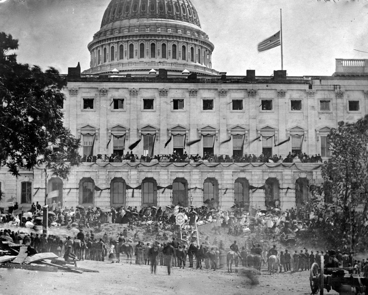 #169 Spectators gather at the side of the Capitol, which is hung with crepe and flies the flag at half mast, during the “grand review” of the Union Army, Washington, D.C., 1865