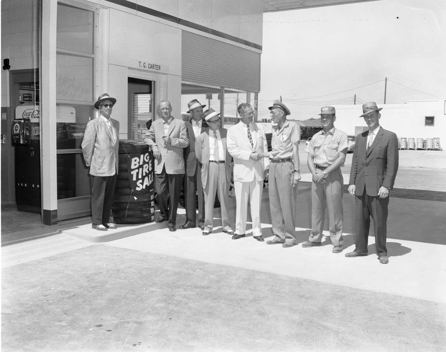 #123 Men standing outside the Magnolia’s Station auto shop on S. First St. in Abilene, 1956