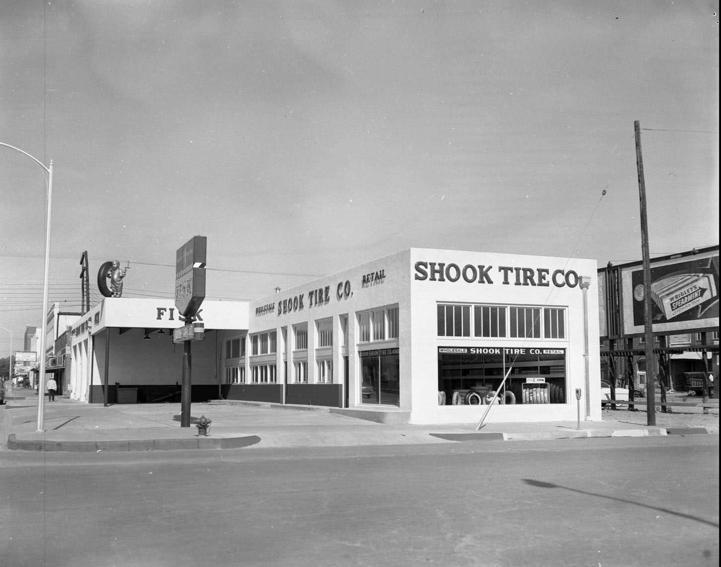 #173 An exterior view of a building identified as Shook Tire Company on Oak Street in Abilene, 1958