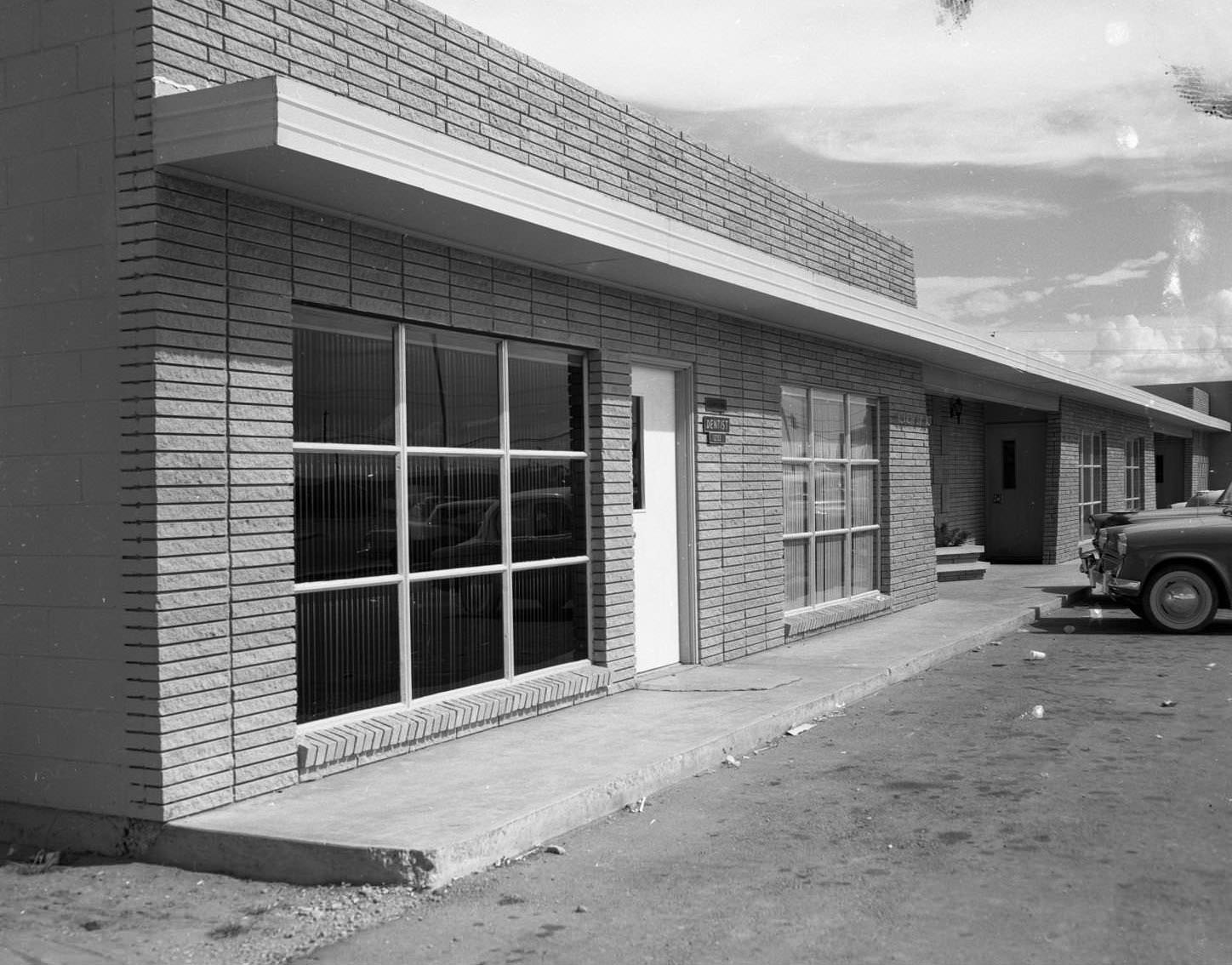 #71 An exterior view of a brick building identified as Doctor Fox’s Office, 1959