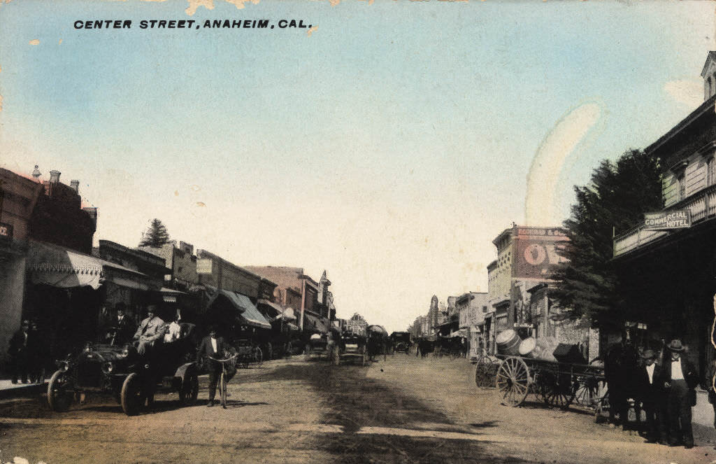 #98 View looking down Center Street (now Lincoln Ave.), with both horse-drawn vehicles and early automobiles visible on the dirt road, 1892