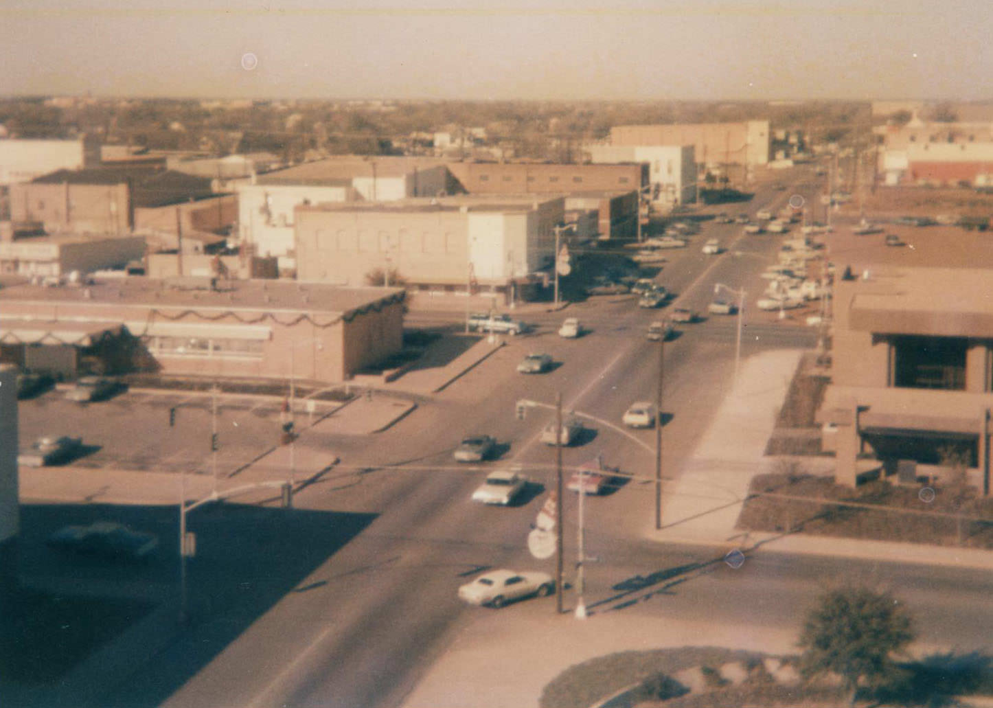 #29 Downtown Arlington with buildings, cars, streets, and power lines, 1973