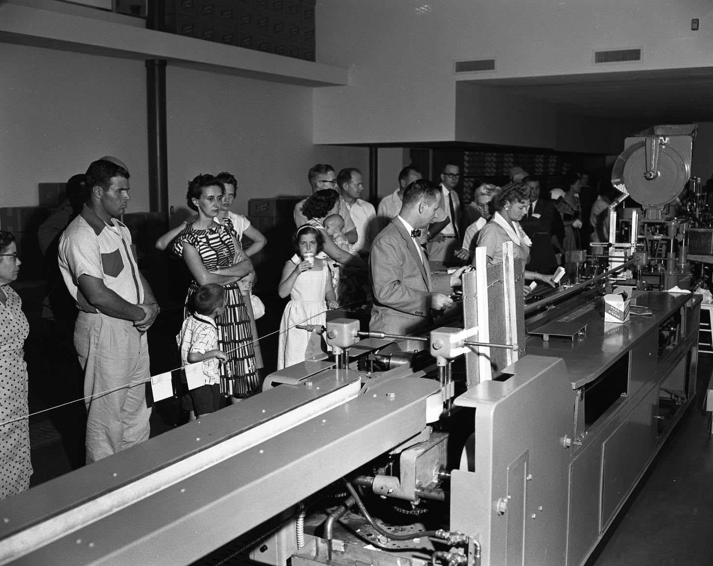 #10 A line of men, women, and children at the Adams Extract factory open house, 1956