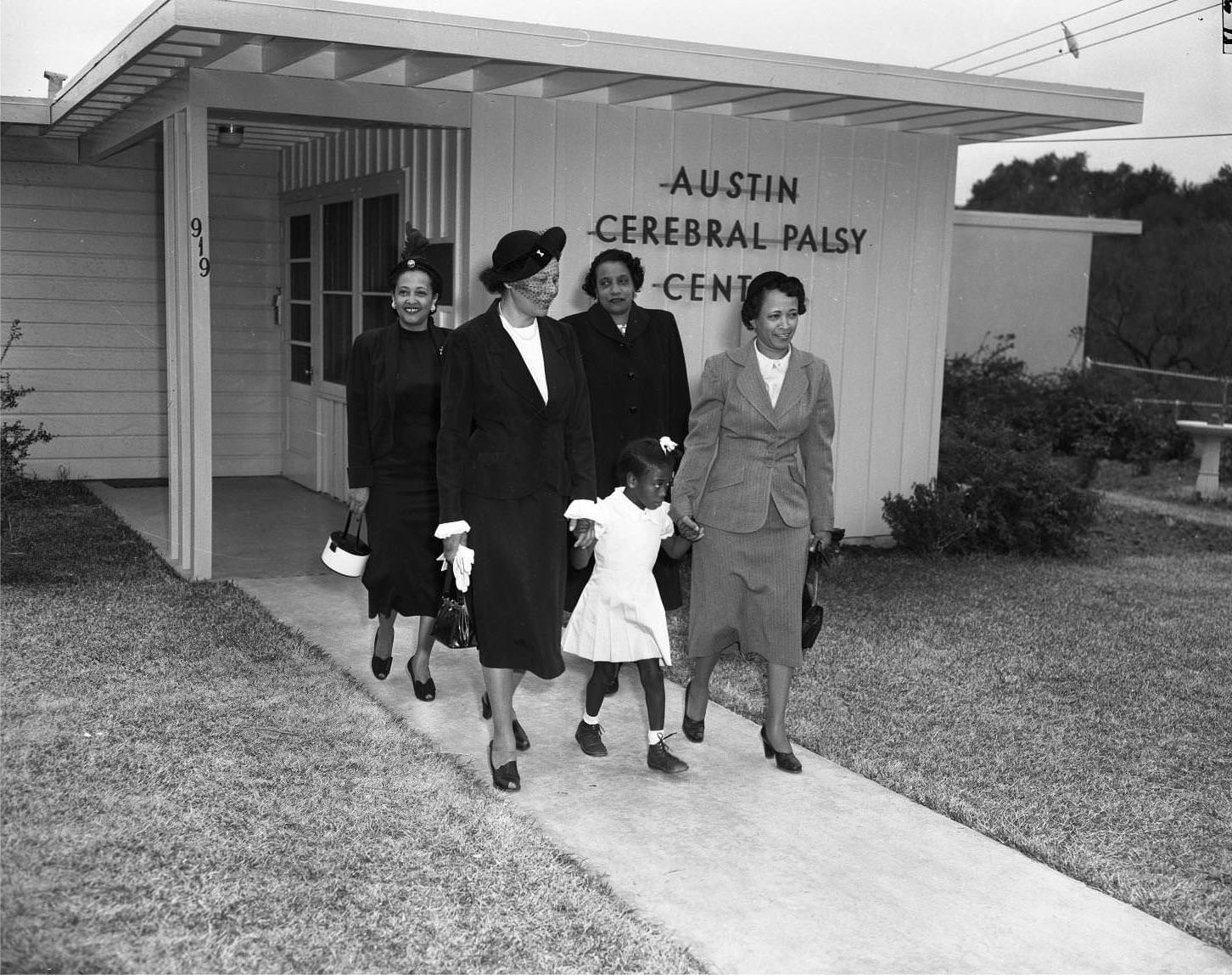 #39 Child with adults at the Austin Cerebral Palsy Center, 1951