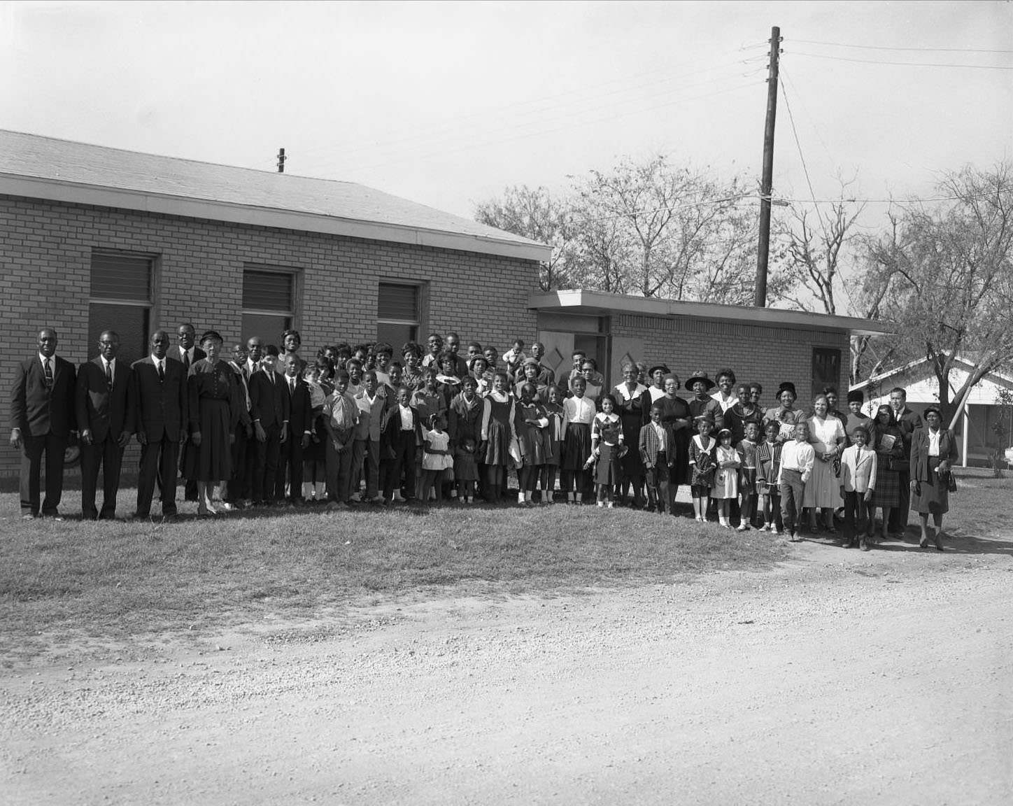 #32 Entire congregation of the Seventh Day Adventists pose together outside church, 1965