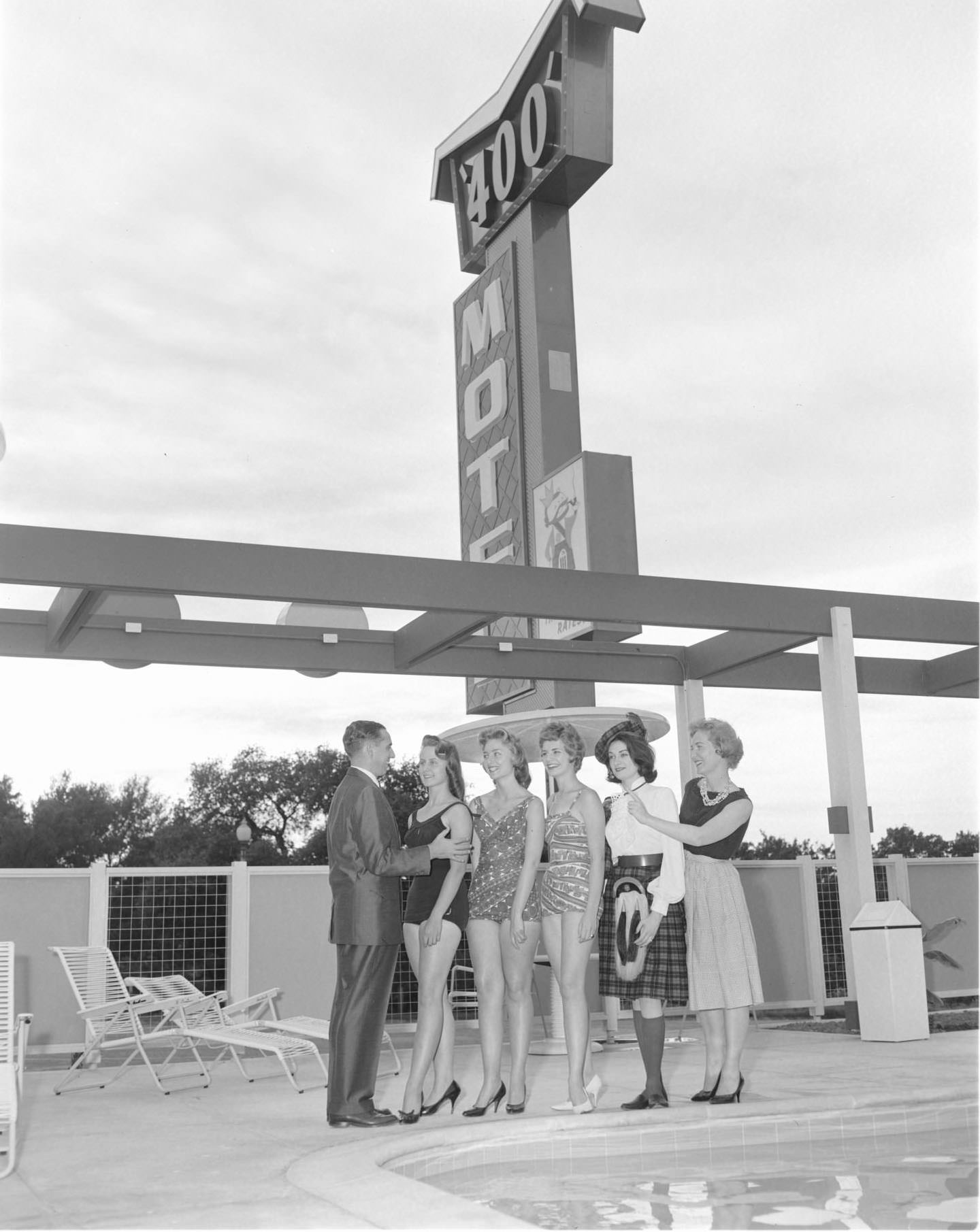 #170 A man and five women near the pool of the Imperial 400 Motel, 1962.