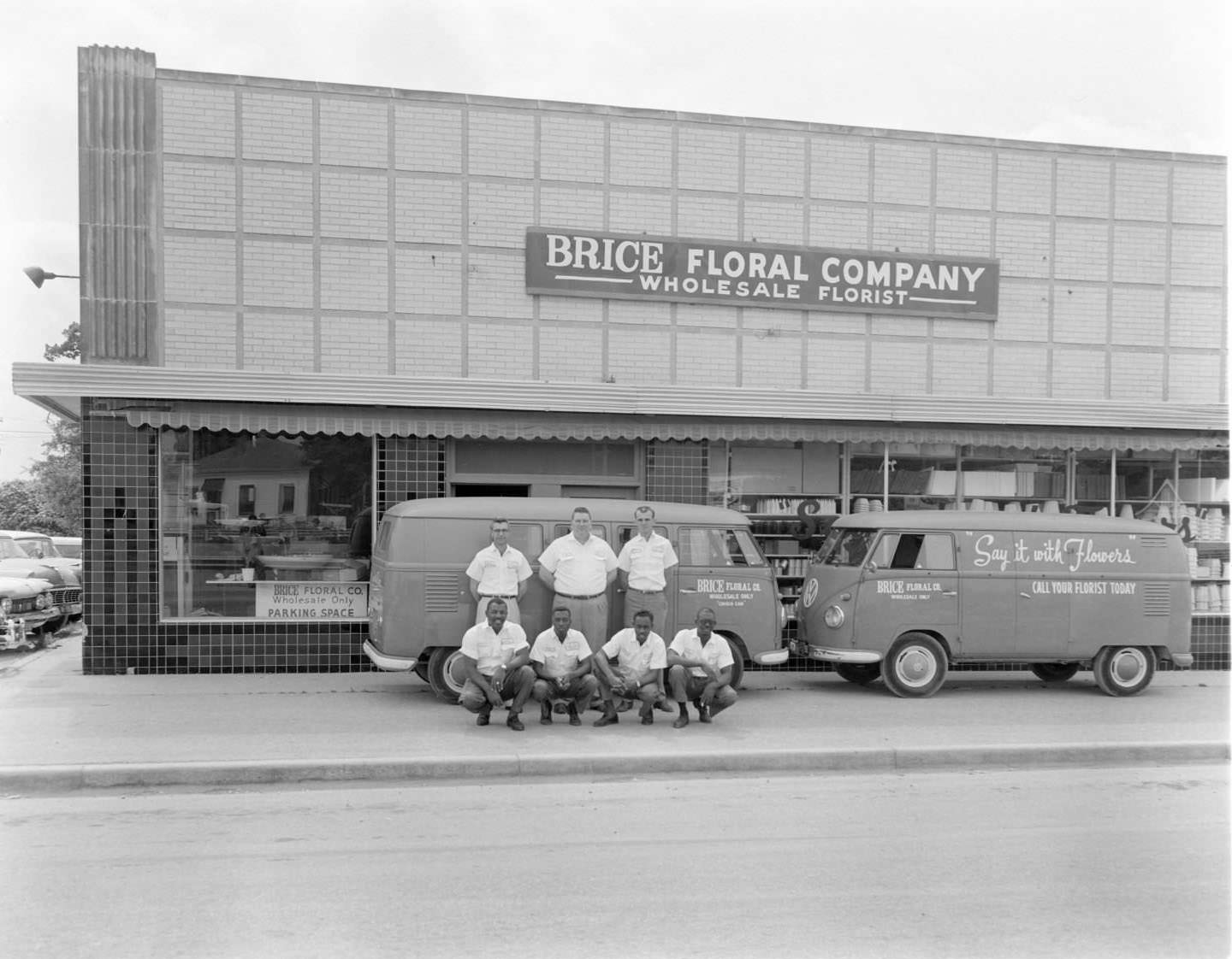 #172 Men posing in front of vans with Brice Floral Company in background. Austin, 1930