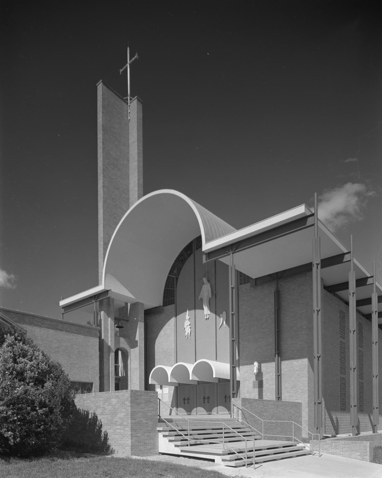 #179 The exterior St. Martin’s Lutheran Church that features and arched, geometric roof line a wide set of steps seen in the foreground, 1960
