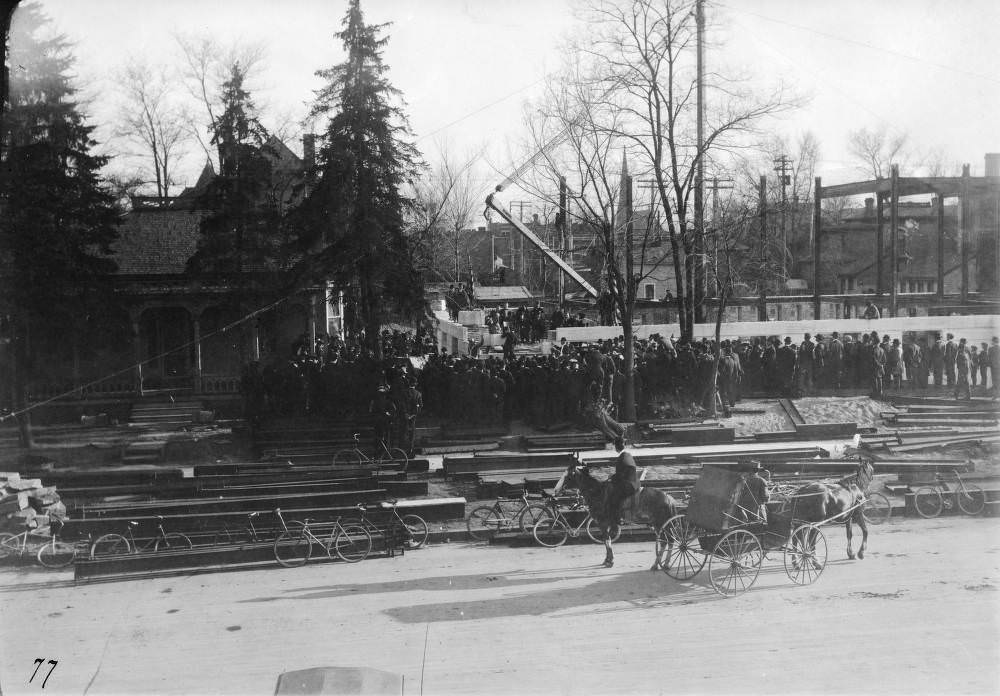 #109 People crowd the Denver Public Library (Carnegie) construction site by a crane to watch the cornerstone ceremony in the Civic Center neighborhood of Denver, 1900