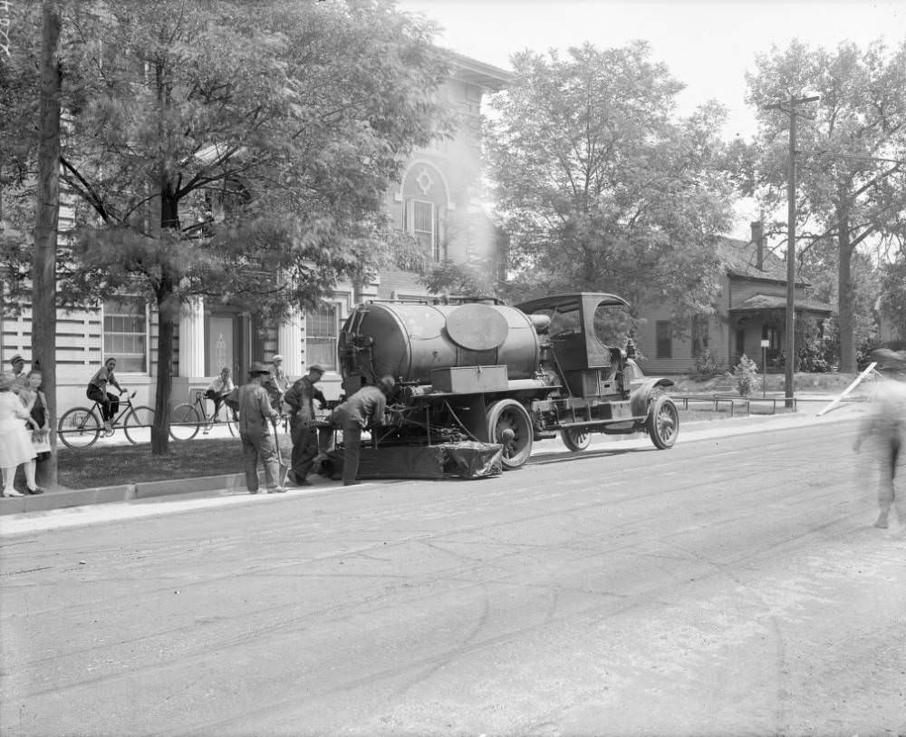 #126 A truck applying oil to a street in Denver, Colorado; brick apartments and a frame house are in the background, 1905