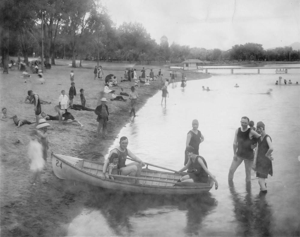 #134 A man, woman and child sit in a rowboat near the shore of Berkeley Park beach on Berkeley Lake in Denver, 1900