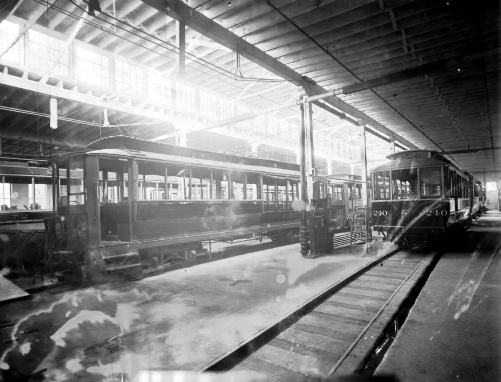 #156 Interior of the Denver Tramway Company garage with trolleys number 195, 151, 72, and 240 at 4th (Fourth) Avenue and Kalamath Street in Denver, 1905