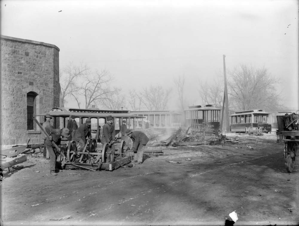 #17 Workers dismantle the chassis and wheels from several old Denver Tramway Company cars in Denver, 1909