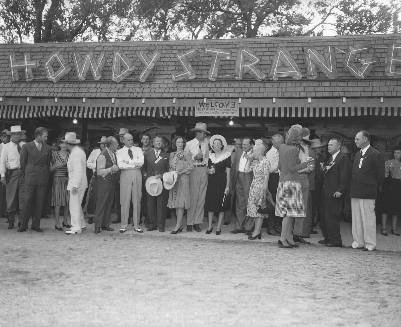 #92 A group poses in front of a “Howdy Stranger” sign at Shady Oak Farm, 1940