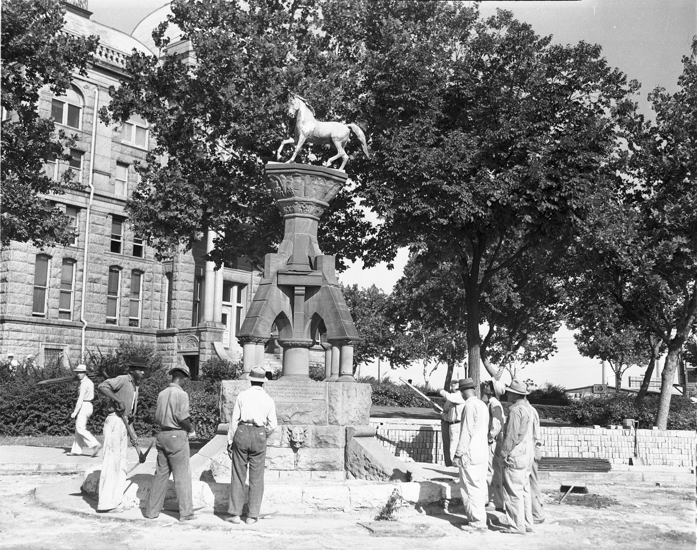 #101 Workmen looking at 48-year-old horse trough on Courthouse Square, downtown Fort Worth, 1940
