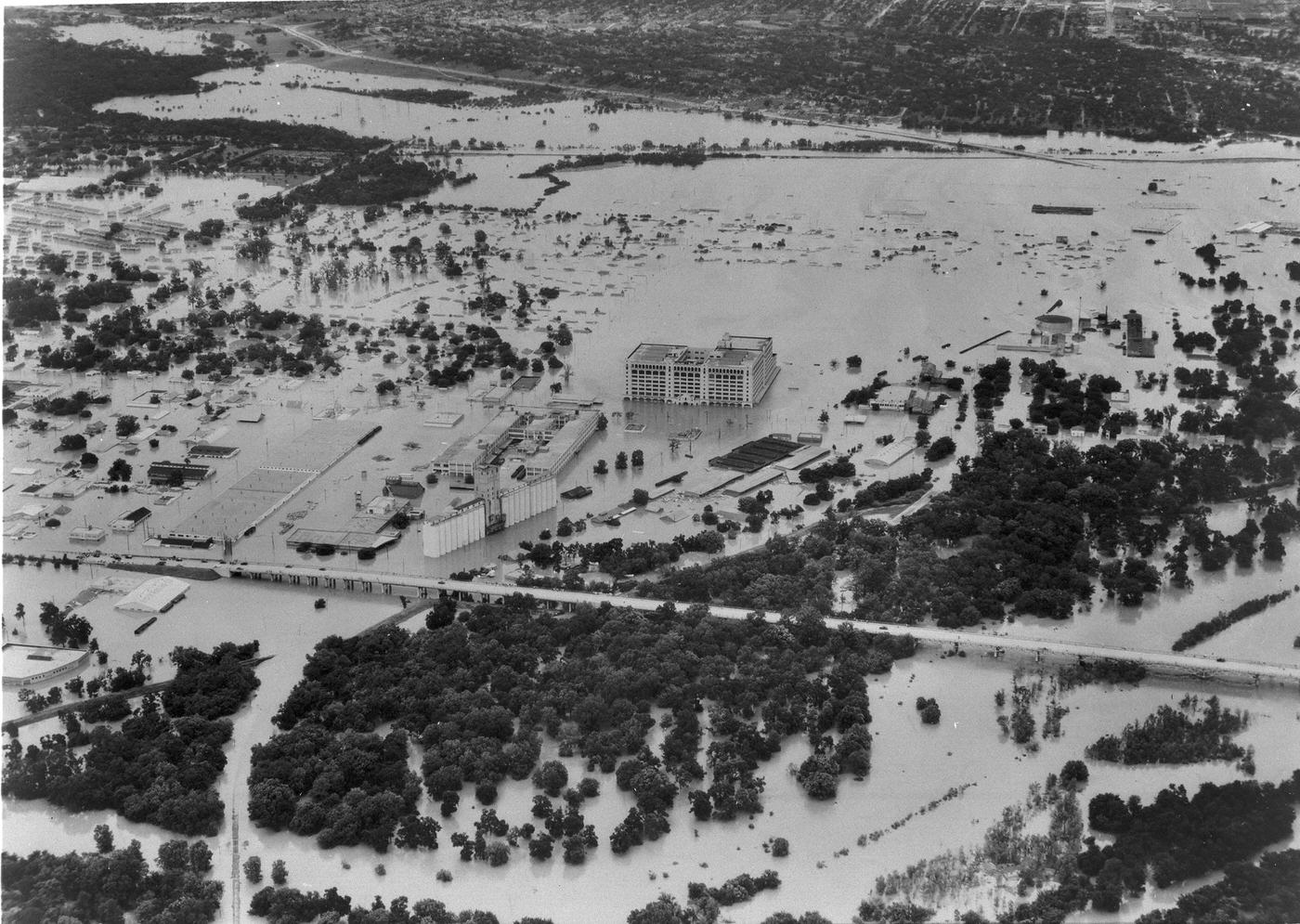 #2 Aerial photo of 1949 flood in Fort Worth showing Trinity River overflowing its banks, 7th St., and Montgomery Ward building, 1949