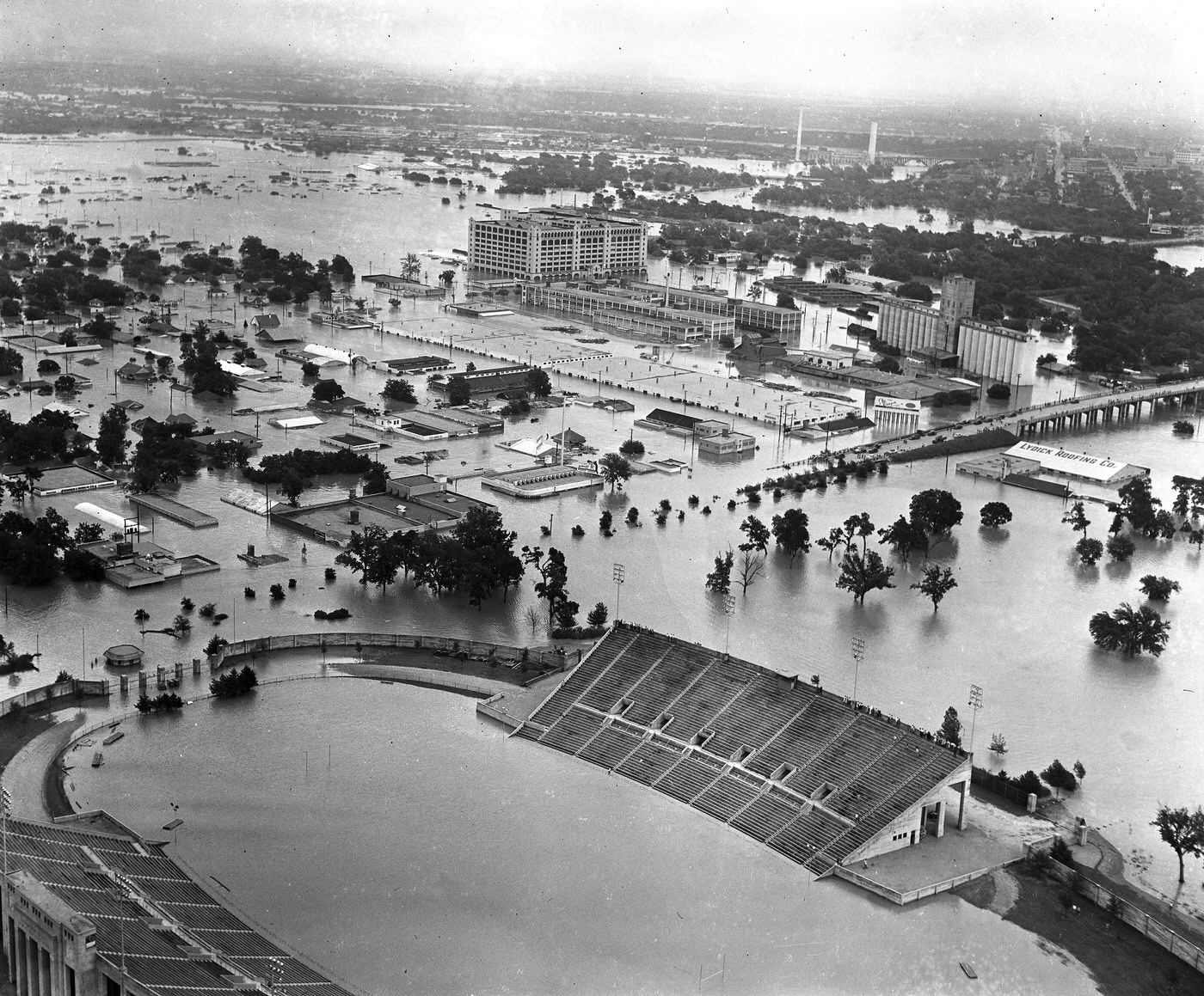 #80 Aerial of 1949 flood in Fort Worth; looking north from Farrington Field high school football stadium toward West Lancaster Street, West 7th Street, and Montgomery Ward, 1949