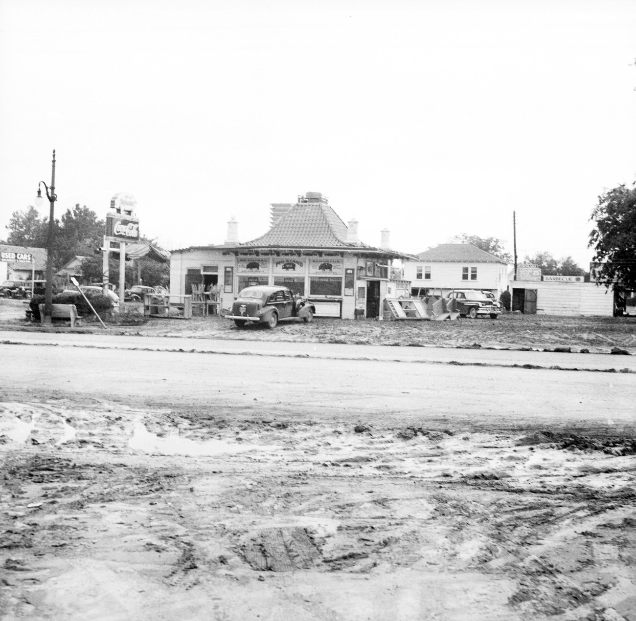 #21 Cars parked in front of stores and shops with Coca-Cola sign in front after the 1949 Fort Worth flood.