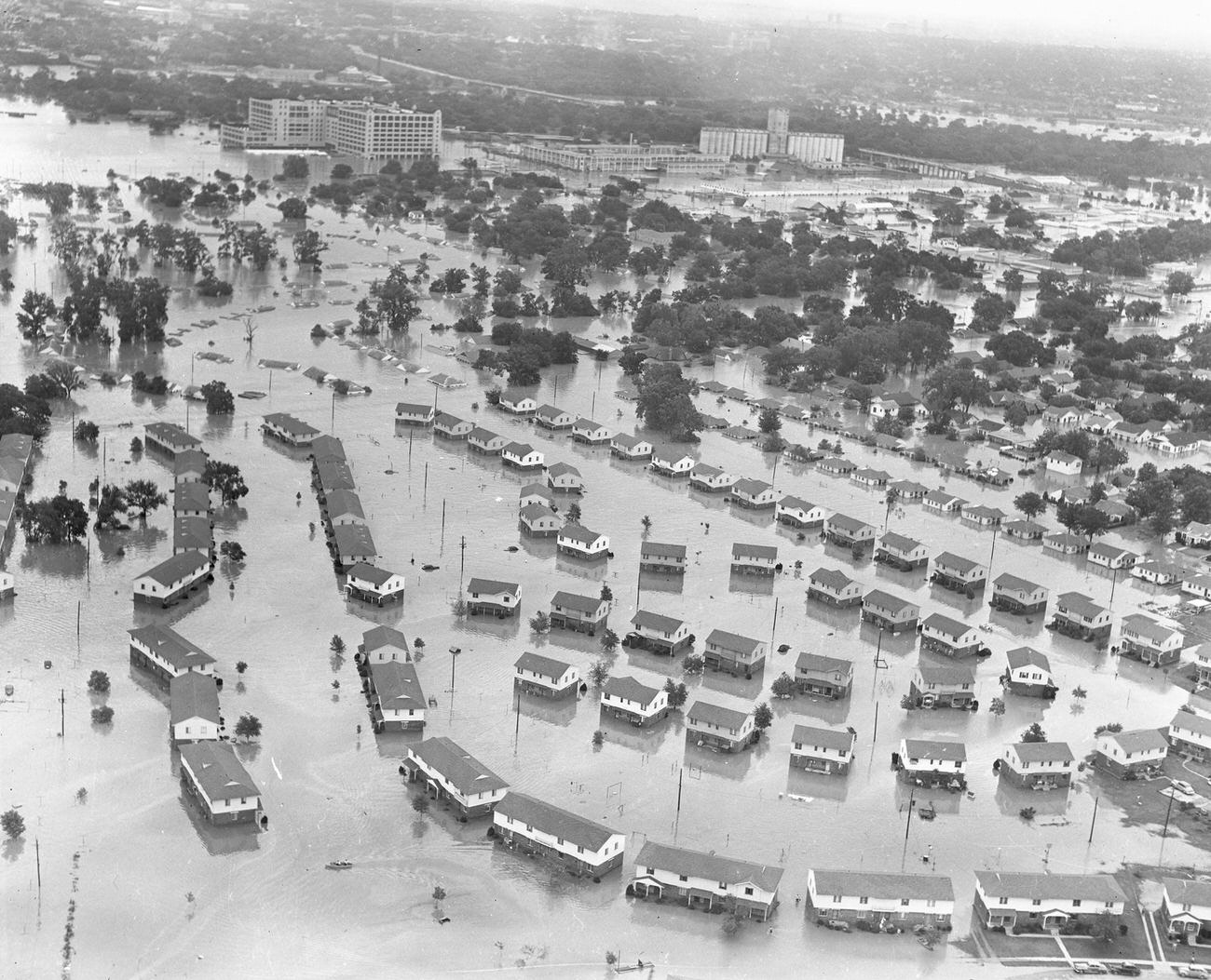#25 Fort Worth, Texas, flood of 1949, showing flooded homes and apartment buildings. The large Montgomery Ward building pictured in the upper left received extensive damage